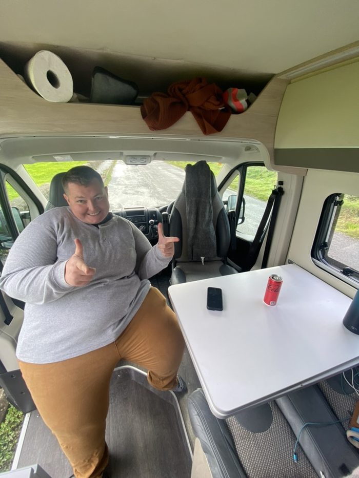 Amanda sitting at the table in a finished van interior.