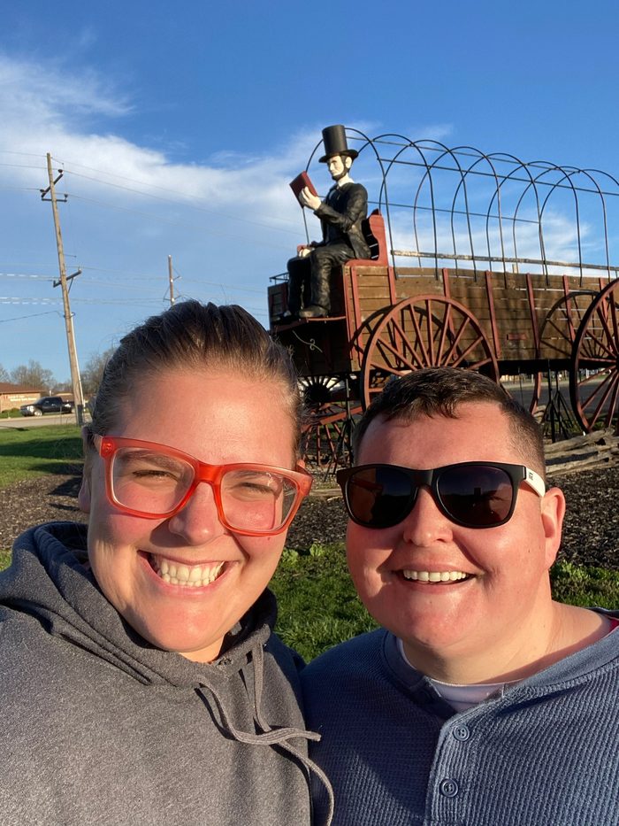 Amanda and Robyn in front of an oversized covered wagon with a Lincoln figure on the seat.